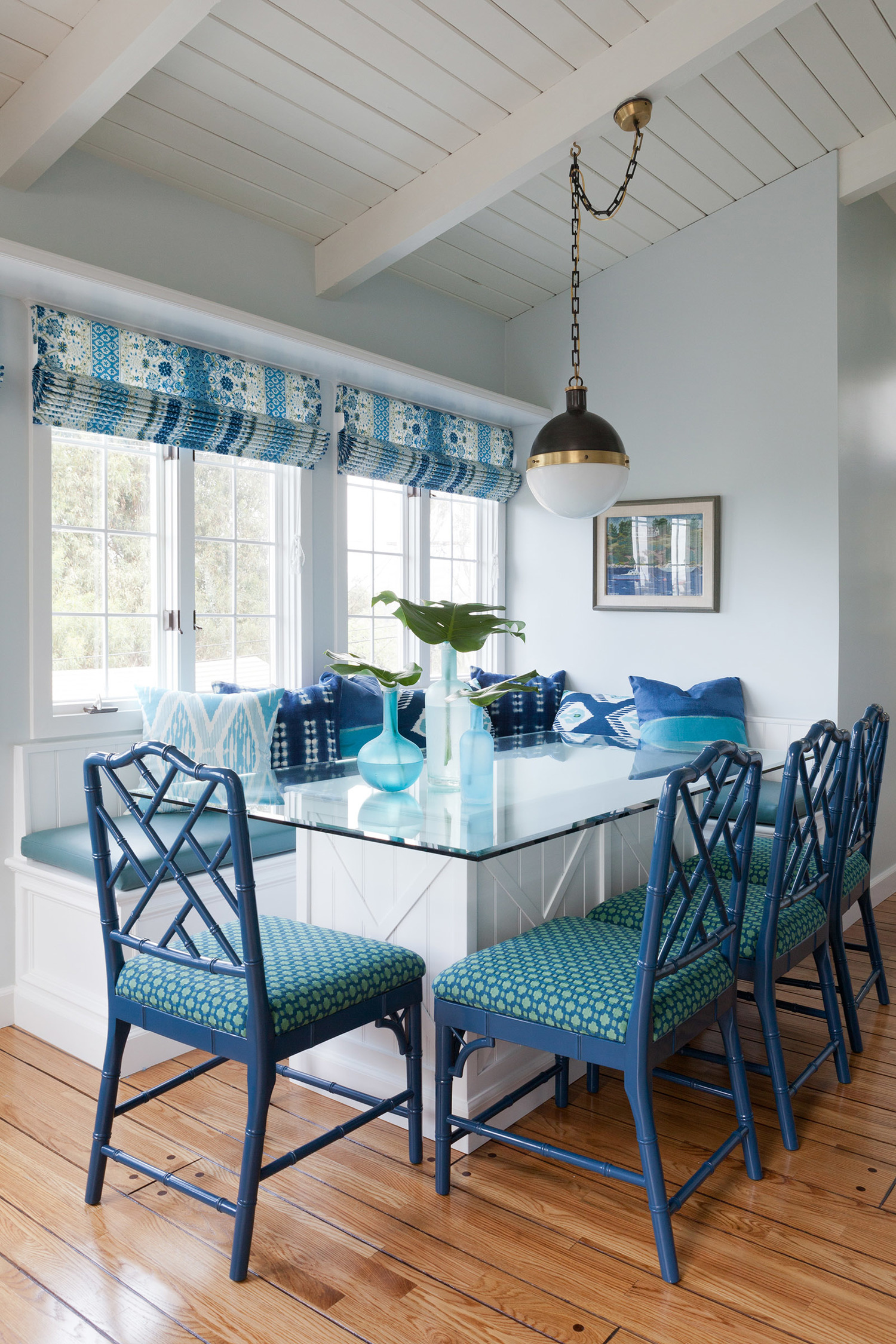 Blue and white roman shades and upholstered dining chairs
